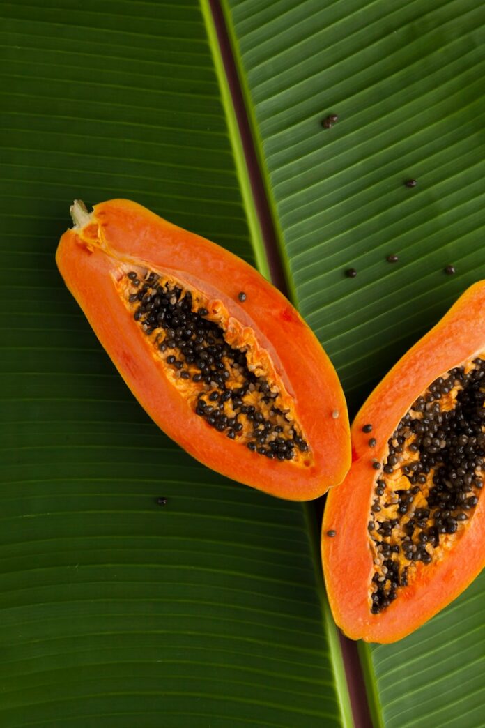 Photo by Bon Vivant sliced papaya on green banana leaf