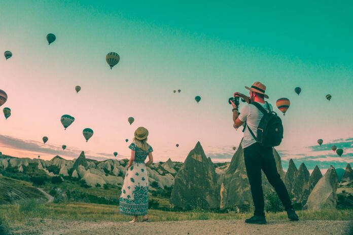 Photo by Mesut Kaya man taking photo of hot air balloons