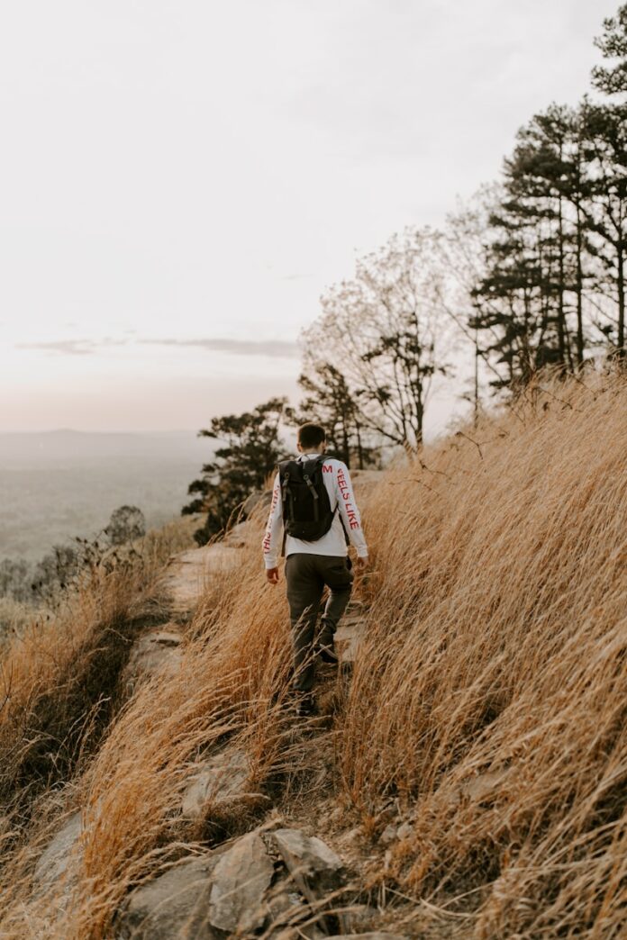 Photo by Hannah Busing woman in black jacket standing on brown grass field during daytime