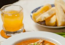 감기 걸렸을 때 피해야 할 음식과 권장 음식 A bowl of soup on a table with a glass of orange juice