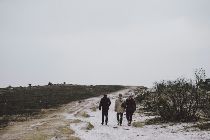 Photo by Annie Spratt three person walking on snow covered field
