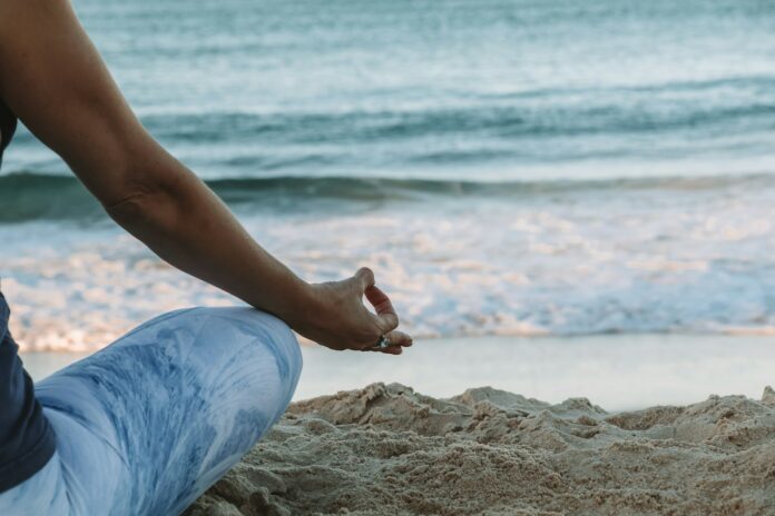 Photo by Chelsea Gates person in blue shorts sitting on beach shore during daytime