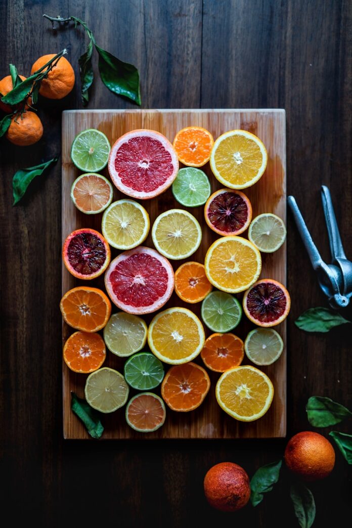 Photo by Odiseo Castrejon assorted sliced citrus fruits on brown wooden chopping board