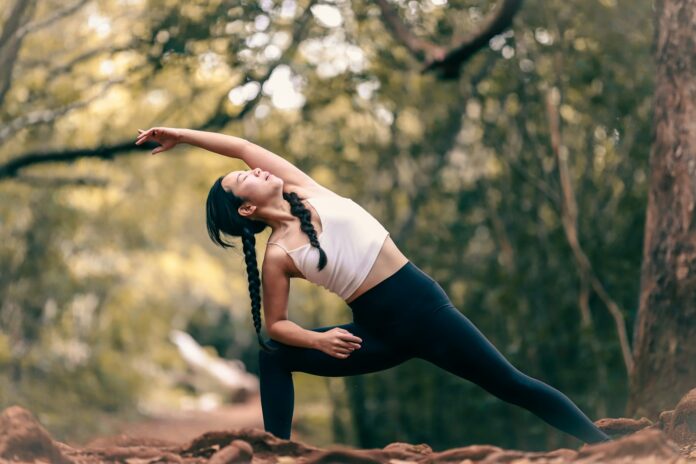 Photo by Luemen Rutkowski woman in white tank top and black leggings doing yoga during daytime