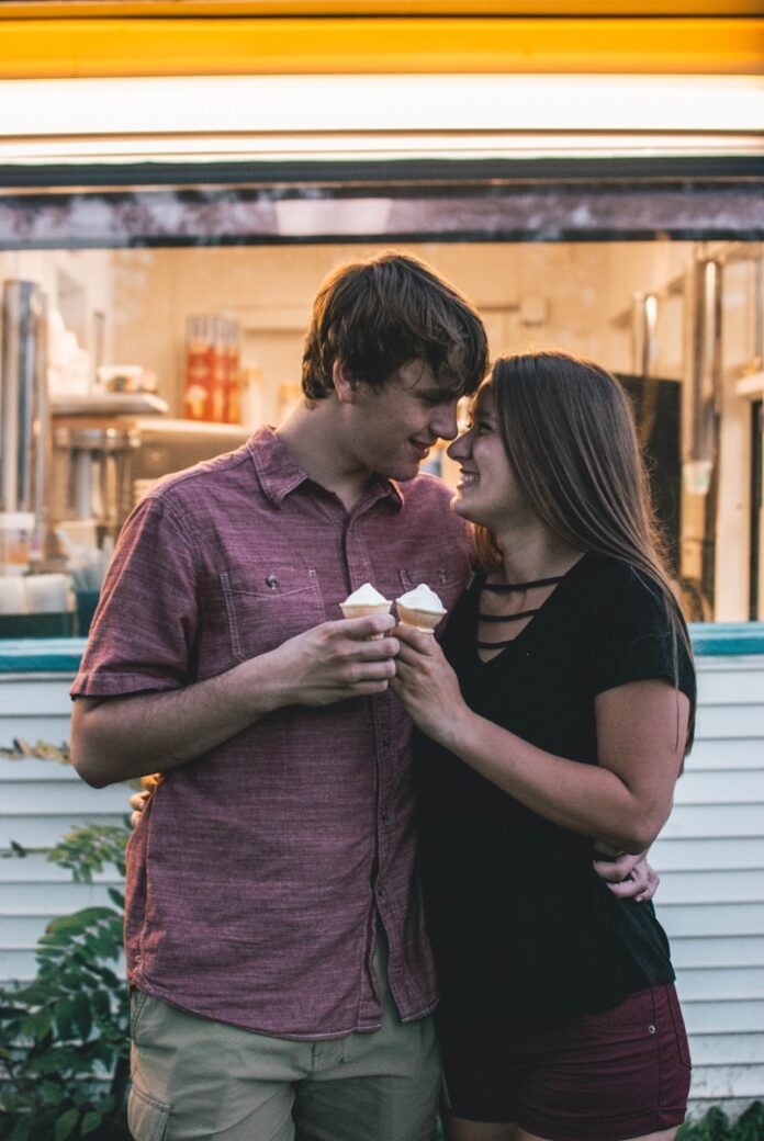 Photo by Brooke Winters man hugging woman while holding ice cream