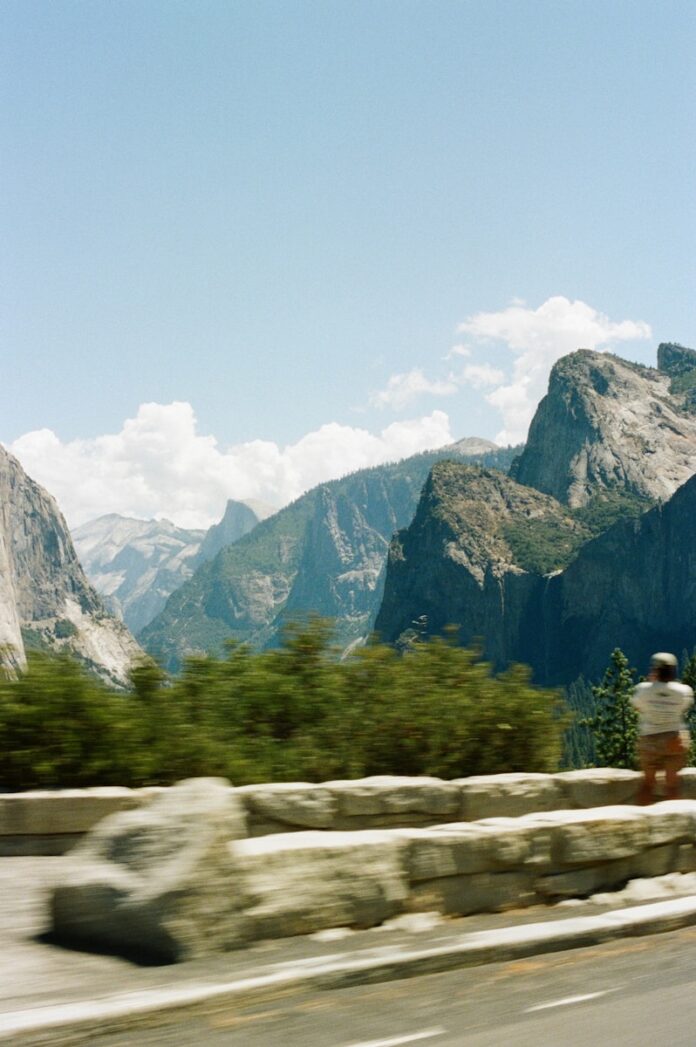 Photo by Spencer Plouzek Man photographing granite cliffs in yosemite national park