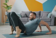 슬림 레그 가이드: 부기 없는 매끈한 다리 라인을 위한 하체 순환 Man doing yoga on a mat in a living room.